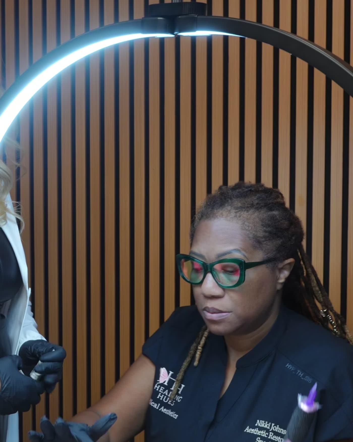 Dr. Rusnak treating a model under the ring light during the August 2026 masterclass