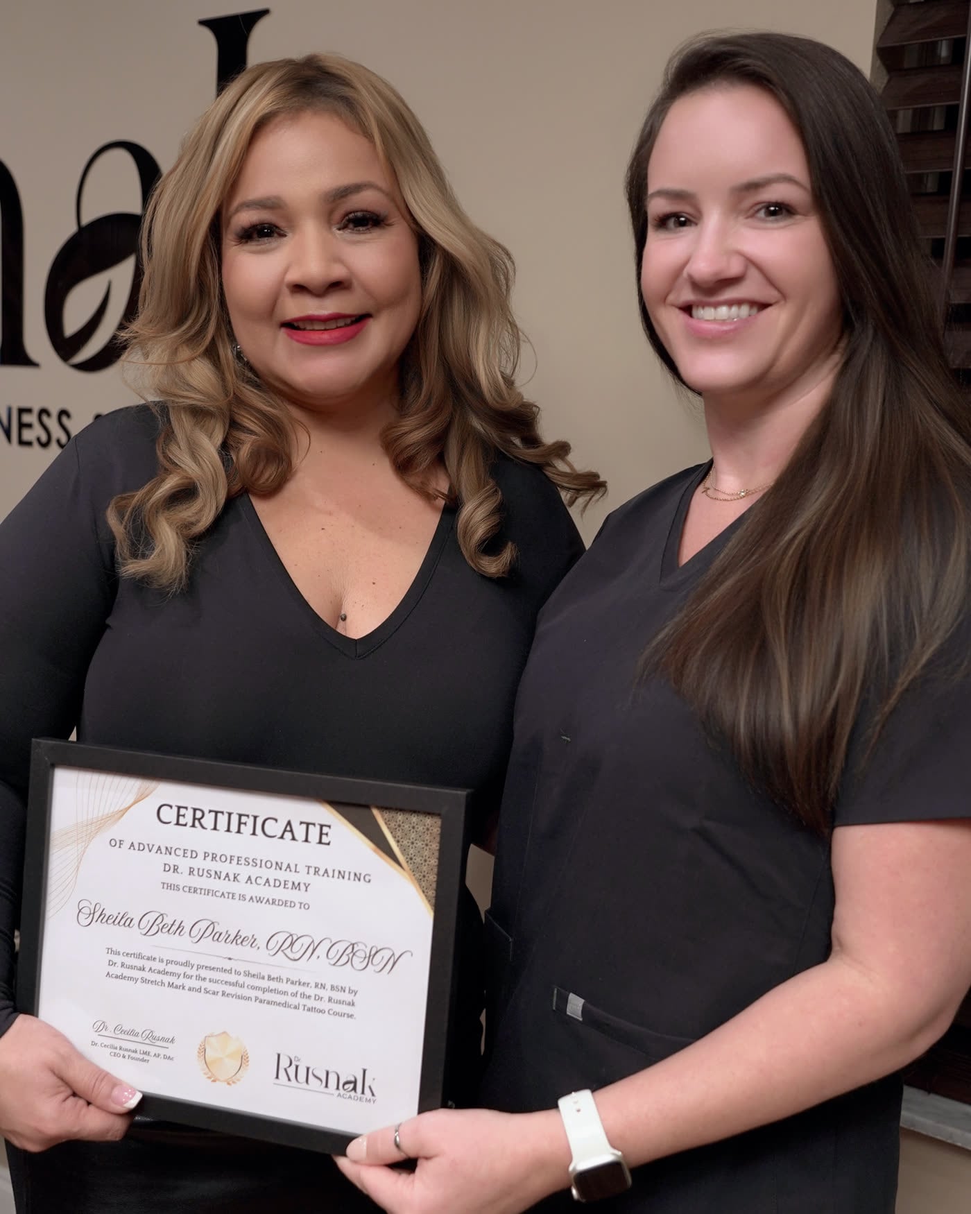 Dr. Rusnak presenting a graduate with her Certificate of Advanced Professional Training